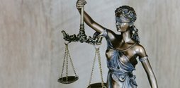 A small bronze statue of Lady Justice holding up scales