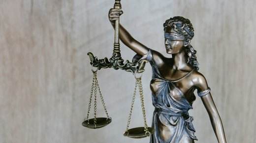 A small bronze statue of Lady Justice holding up scales