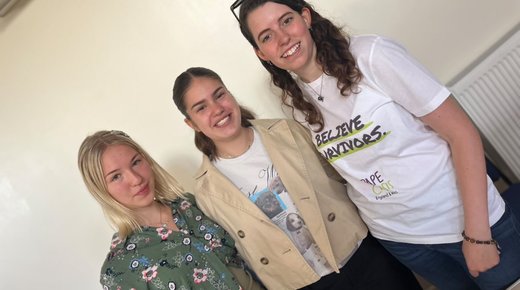 A photo of three smiling caucasian women, the one on the right is wearing a Rape Crisis tee-shirt